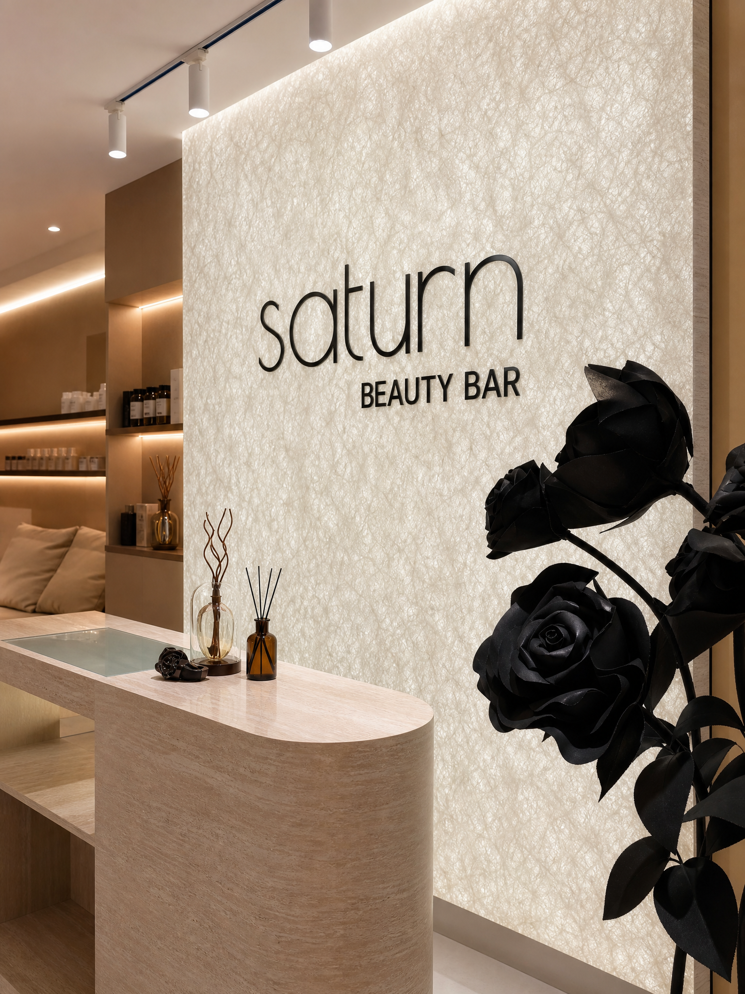 Saturn Beauty reception with warm stone, black floral details and Saturn signage