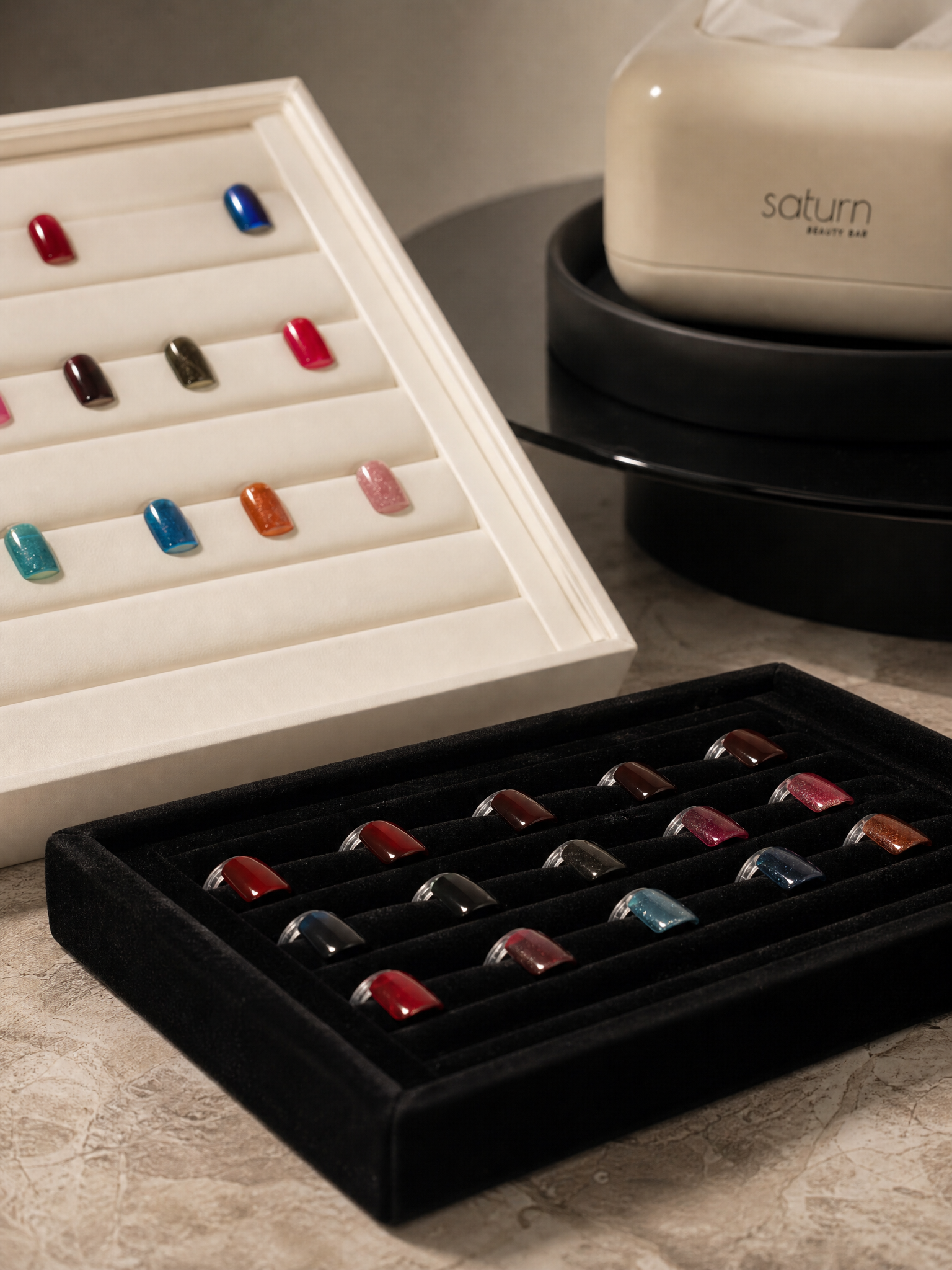 Saturn Beauty nail colour palettes arranged on warm stone